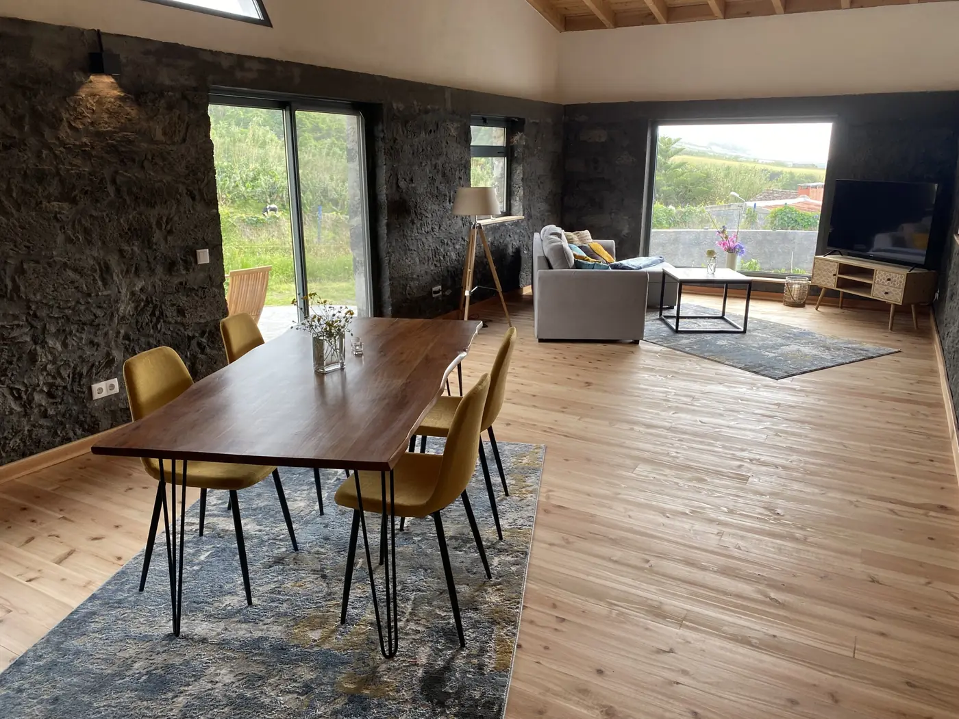 The long dining table at Casa de Sonho in front of the old volcanic stone wall