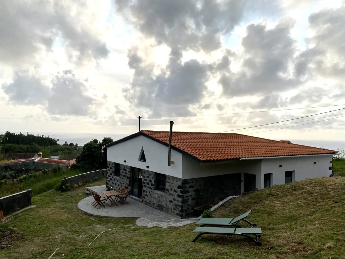 A Casa de Sonho ao anoitecer, com nuvens sobre o Atlântico ao fundo