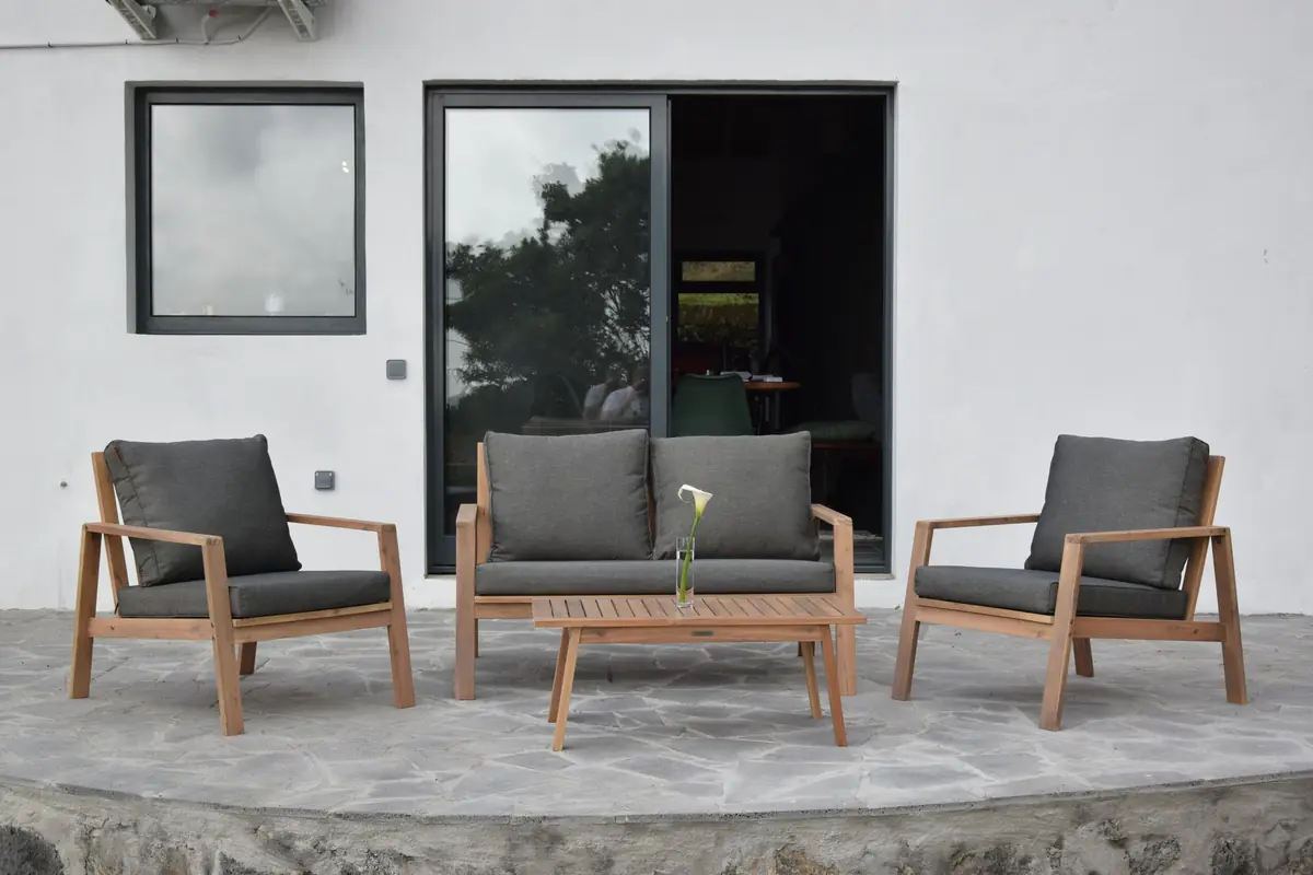 O terraço-lounge da Casa de Sonho, com mobiliário de madeira encostado à parede branca